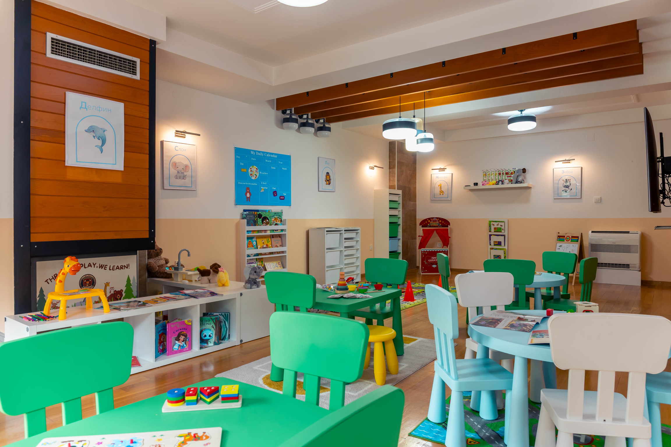 Tidy learning corner with books, toys, and child-sized tables
